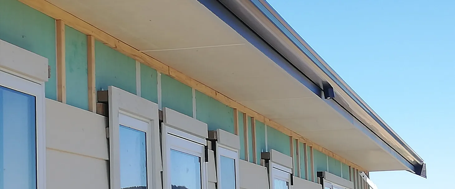 A long unbroken run of new colour steel spouting and fascia against a clear sky
